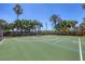 Outdoor basketball court with green surface, white lines, black fence, and surrounding mature landscaping at 1021 Ancora Blvd, North Venice, FL 34275