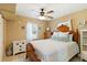 Cozy bedroom featuring ceiling fan, hardwood furniture, and decor featuring coastal designs at 108 Martin Ne Dr, Port Charlotte, FL 33952