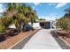 Well maintained home featuring covered carport and concrete driveway with mature trees and landscaping at 108 Martin Ne Dr, Port Charlotte, FL 33952