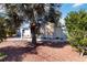 Single story home with mature trees, rock landscaping, and a charming, covered front porch at 108 Martin Ne Dr, Port Charlotte, FL 33952