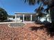 Charming single story home featuring covered porch, fresh landscaping, and mature palm trees at 108 Martin Ne Dr, Port Charlotte, FL 33952