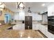 Modern kitchen featuring white cabinets, stainless steel appliances, granite counters, and decorative lighting at 108 Martin Ne Dr, Port Charlotte, FL 33952