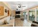 Bright living room with three ceiling fans, coastal decor, and screened patio access at 108 Martin Ne Dr, Port Charlotte, FL 33952