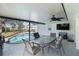Inviting covered patio with ceiling fan, dining area, and poolside views ideal for relaxation and entertainment at 108 Martin Ne Dr, Port Charlotte, FL 33952