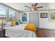 Bright bedroom features a ceiling fan, wood floors, and ample natural light from multiple windows at 11 1St E St, Nokomis, FL 34275