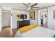 Bright bedroom features wood floors, a ceiling fan and a large dresser topped with a television and colorful decor at 11 1St E St, Nokomis, FL 34275