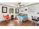 This well-lit bedroom is decorated with art, bright chair and daybed with an ample view of the outdoors at 11 1St E St, Nokomis, FL 34275