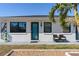 Close up of charming home with white stucco and black trim with chairs in front of blue door at 11 1St E St, Nokomis, FL 34275