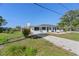 The exterior of this home features fresh paint, green grass, gravel driveway, and beautiful plants at 11 1St E St, Nokomis, FL 34275