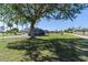 Charming home features a large tree providing ample shade in the well-manicured front lawn and driveway at 11 1St E St, Nokomis, FL 34275