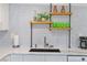 Kitchen featuring floating shelves with colorful decor and a geometric backsplash at 11 1St E St, Nokomis, FL 34275