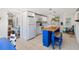 Open kitchen featuring white appliances, blue island and floating shelving at 11 1St E St, Nokomis, FL 34275