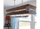 Contemporary wood-framed light fixture with glass details illuminates the dining area at 11 1St E St, Nokomis, FL 34275