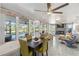 Open concept living area with dining table and chairs featuring expansive windows and seamless access to the living room at 11 1St E St, Nokomis, FL 34275