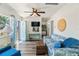Bright living room with a blue sofa, ceiling fan, and access to the outdoors at 11 1St E St, Nokomis, FL 34275