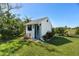 Exterior view of the shed surrounded by lush greenery and a well-maintained lawn at 11 1St E St, Nokomis, FL 34275