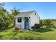 Exterior view of the charming shed in the backyard, surrounded by lush greenery at 11 1St E St, Nokomis, FL 34275