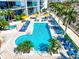 Aerial view of pool and sun loungers with palms and city buildings beyond at 1155 N Gulfstream Ave # 508, Sarasota, FL 34236