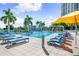 Poolside with palms, bright sun loungers, and city buildings beyond at 1155 N Gulfstream Ave # 508, Sarasota, FL 34236
