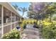 Manicured backyard with patio and screened-in porch, showcasing mature landscaping and a peaceful setting at 125 Golf Club Ln, Venice, FL 34293
