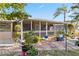 Charming backyard with a screened porch, lush landscaping, and serene outdoor living space at 125 Golf Club Ln, Venice, FL 34293
