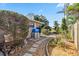 Landscaped backyard features stone pathway, mulch beds and verdant plantings under bright blue skies at 125 Golf Club Ln, Venice, FL 34293