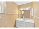 Bathroom featuring patterned wallpaper, a large mirror over a white vanity, and ample lighting at 125 Golf Club Ln, Venice, FL 34293