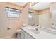 Cozy bathroom featuring patterned wallpaper, a sink and vanity, and a combined shower and tub at 125 Golf Club Ln, Venice, FL 34293
