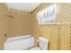 Bathroom with charming patterned wallpaper, featuring a shower-tub combo and a comfort-height toilet at 125 Golf Club Ln, Venice, FL 34293