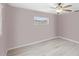 Neutral bedroom featuring wood-look flooring, a ceiling fan with lighting, and a window with blinds at 125 Golf Club Ln, Venice, FL 34293