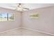 Neutral bedroom with wood-look floors, with view of golf course through two windows at 125 Golf Club Ln, Venice, FL 34293