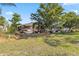 Well-maintained front yard with lush landscaping, mature trees, and cozy seating at 125 Golf Club Ln, Venice, FL 34293