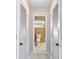 Hallway view into a bathroom, flanked by white louvered closet doors at 125 Golf Club Ln, Venice, FL 34293