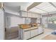 Open kitchen with white cabinets, a wood countertop, and a breakfast bar overlooking the adjacent living area at 125 Golf Club Ln, Venice, FL 34293