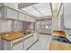 Bright kitchen featuring tiled floors, wood countertops, and white cabinets, leading to an adjacent dining area at 125 Golf Club Ln, Venice, FL 34293