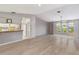 Inviting open-plan space with light wood flooring, seamlessly connecting the living area and kitchen at 125 Golf Club Ln, Venice, FL 34293