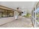 Inviting screened patio featuring brick floors, a ceiling fan, and views of the yard at 125 Golf Club Ln, Venice, FL 34293