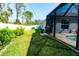 Well-maintained backyard featuring a screened-in pool area and a lush green lawn at 13339 Flaherty Ave, Port Charlotte, FL 33981