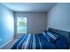 Comfortable bedroom with a blue striped bedspread and a bright window view at 13339 Flaherty Ave, Port Charlotte, FL 33981