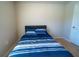 Simple bedroom with a comfortable bed, neutral walls, and a white door at 13339 Flaherty Ave, Port Charlotte, FL 33981