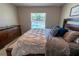 Well-lit bedroom with a queen-size bed, dresser, and window overlooking the pool area at 13339 Flaherty Ave, Port Charlotte, FL 33981