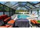 Inviting screened-in pool area featuring outdoor seating and a covered pool at 13339 Flaherty Ave, Port Charlotte, FL 33981