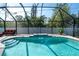 Beautiful screened-in pool area with a seating area and lush greenery, perfect for relaxation at 13339 Flaherty Ave, Port Charlotte, FL 33981