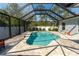 Relaxing screened-in pool area with stone pavers and lush landscaping at 13339 Flaherty Ave, Port Charlotte, FL 33981