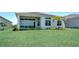Spacious backyard featuring a large green lawn and a modern home with large windows, perfect for outdoor enjoyment at 17916 Palmiste Dr, Bradenton, FL 34202