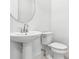 Cozy powder room with a pedestal sink, toilet, and crisp white paint at 17916 Palmiste Dr, Bradenton, FL 34202