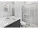 Modern bathroom with a vanity, toilet, and glass-enclosed shower with tiled walls at 17916 Palmiste Dr, Bradenton, FL 34202