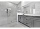 Modern bathroom featuring a glass shower, gray vanity, and elegant tile work at 17916 Palmiste Dr, Bradenton, FL 34202