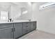 Bright bathroom with a large mirror, double sinks, gray vanity, and stylish herringbone flooring at 17916 Palmiste Dr, Bradenton, FL 34202