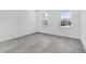 A bright, empty bedroom featuring stylish herringbone flooring and two large windows at 17916 Palmiste Dr, Bradenton, FL 34202